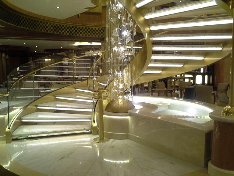 Royal Princess Atrium Fountain.  Covering of solid curved pieces crema marfil marble
